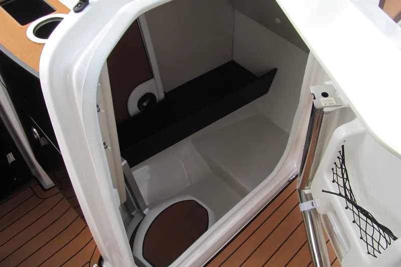 Slide: The Image of 2025 Yamaha Boats 252SD interior cabin with wood flooring and storage space. - 10