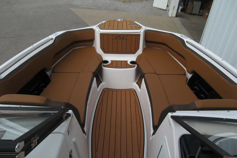 Slide: The Image of 2025 Yamaha Boats 252SD interior with brown seating and wood-style flooring. - 12