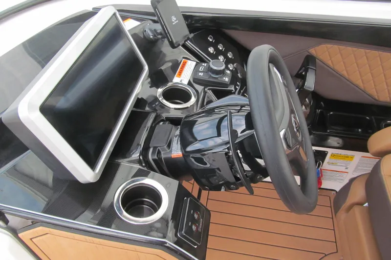 Slide: The Image of 2025 Yamaha Boats 252SD helm with touchscreen, steering wheel, and cup holders. - 15