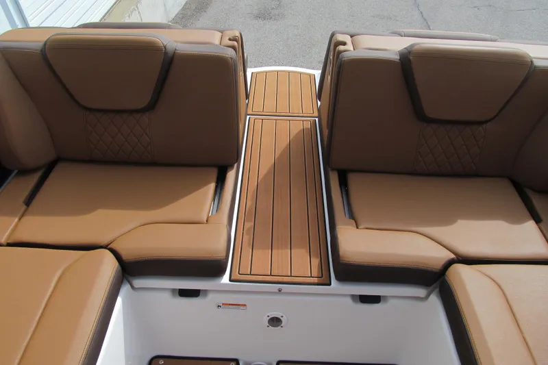 Slide: The Image of 2025 Yamaha Boats 252SD interior with brown cushioned seating and wooden deck. - 16