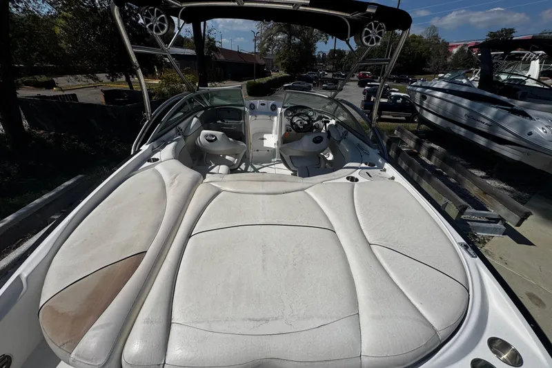 Slide: The Image of 2008 Rinker 226 Captiva Bowrider with spacious seating and sleek design, docked outdoors. - 4