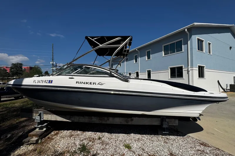 Slide: The Image of 2008 Rinker 226 Captiva Bowrider boat on display outdoors, with a blue building backdrop. - 8