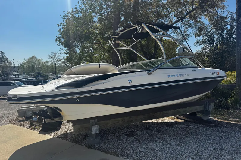 Slide: The Image of 2008 Rinker 226 Captiva Bowrider boat on display outdoors, surrounded by trees. - 9