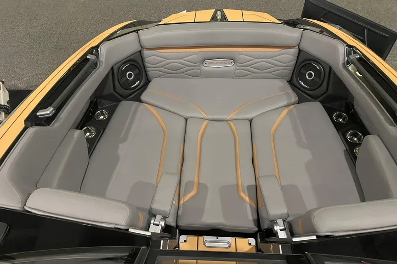Slide: The Image of 2025 Supra SA boat interior with gray and orange seating, integrated speakers, and cup holders. - 2