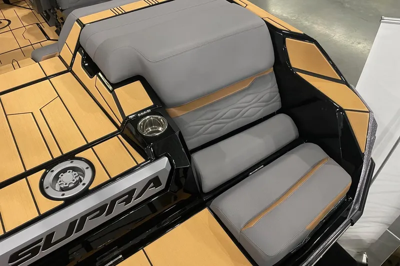 Slide: The Image of 2025 Supra SA boat interior with gray and tan seating, cup holder, and stylish design. - 4