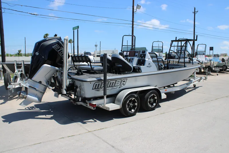 Slide: The Image of 2023 Mamba 24VX boat interior with seating and speakers, docked on a sunny day. - 10