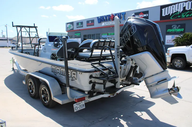 Slide: The Image of 2023 Mamba 24VX boat interior with seating and storage, displayed outdoors. - 12