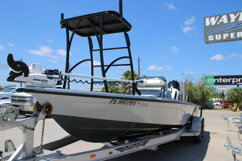 Slide: The Image of 2023 Mamba 24VX boat with powerful outboard motor, parked in a dealership lot. - 8