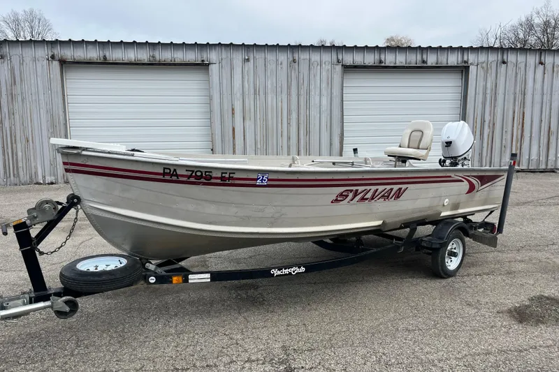 Slide: The Image of 2004 Sylvan 1600 Super Snapper boat on trailer, parked in front of metal garage doors. - 10