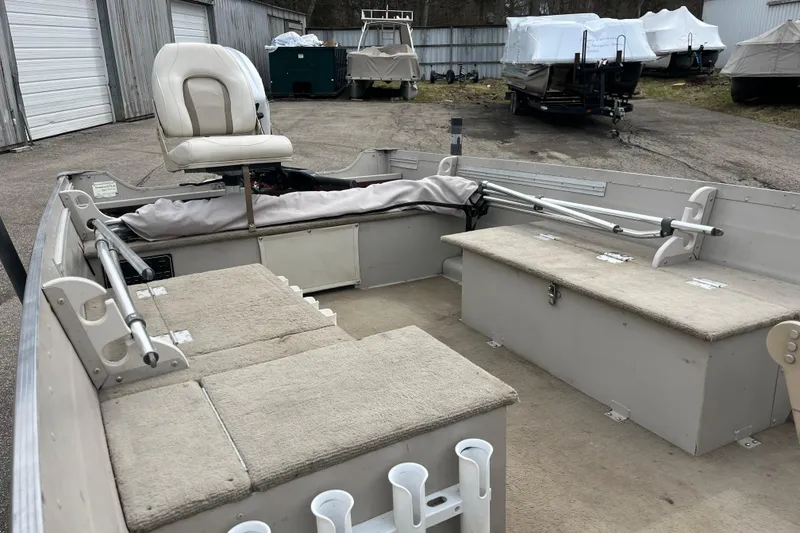 Slide: The Image of 2004 Sylvan 1600 Super Snapper boat interior with seating and storage compartments. - 8