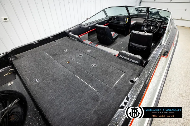 Slide: The Image of 1992 Stratos 290 Ski-N-Fish boat interior with seating and dashboard, showcased in a showroom. - 10