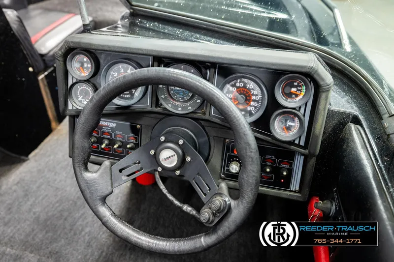 Slide: The Image of 1992 Stratos 290 Ski-N-Fish boat dashboard with steering wheel and gauges. - 24