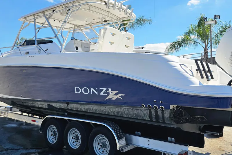 Slide: The Image of 2004 Donzi 38 ZSF boat on trailer, featuring sleek design and vibrant blue hull. - 1
