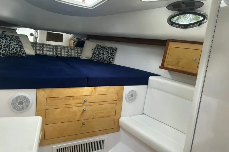 Slide: The Image of Interior cabin of a 2004 Donzi 38 ZSF boat with blue bedding and wooden cabinetry. - 13