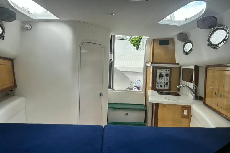 Slide: The Image of Interior of a 2004 Donzi 38 ZSF boat featuring a compact kitchen and seating area. - 15
