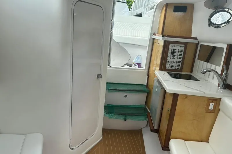 Slide: The Image of 2004 Donzi 38 ZSF boat interior with kitchenette, sink, and control panel. - 16