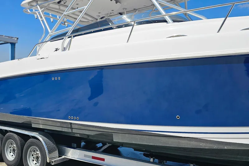 Slide: The Image of 2004 Donzi 38 ZSF boat on trailer, featuring sleek blue and white design. - 19