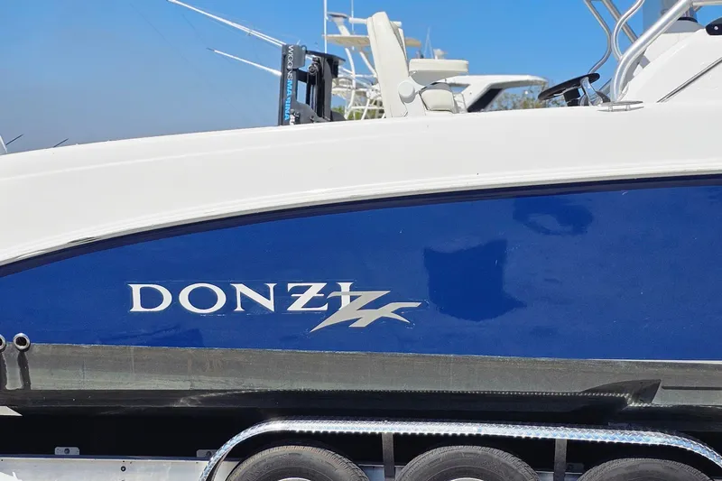 Slide: The Image of 2004 Donzi 38 ZSF boat with blue and white exterior on a trailer. - 2
