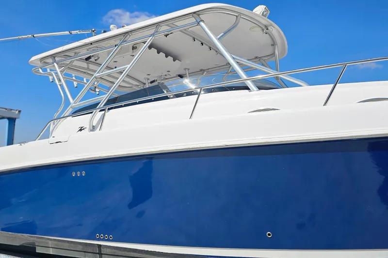 Slide: The Image of 2004 Donzi 38 ZSF boat with blue hull and white top against clear sky. - 20