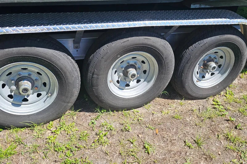 Slide: The Image of Trailer wheels for a 2004 Donzi 38 ZSF boat on grassy ground. - 39