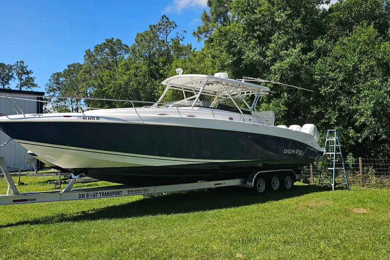 Slide: The Image of 2004 Donzi 38 ZSF boat on trailer, parked on grass with trees in background. - 41