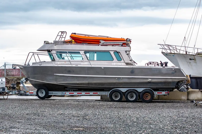 The Image of 2003 Lifetimer 3050 Pleasure Cabin boat on trailer, with orange lifeboat on top. - 0