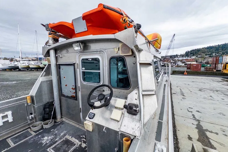 Slide: The Image of 2003 Lifetimer 3050 Pleasure Cabin boat with orange lifeboat, docked at a marina. - 11