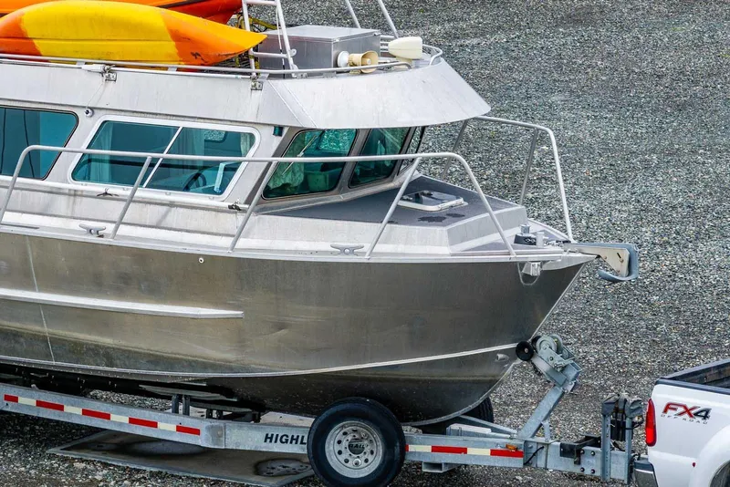 Slide: The Image of 2003 Lifetimer 3050 Pleasure Cabin boat on trailer with kayaks on top. - 2