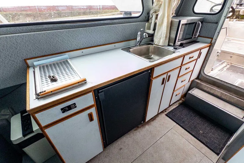 Slide: The Image of 2003 Lifetimer 3050 Pleasure Cabin kitchen with sink, microwave, and storage cabinets. - 24