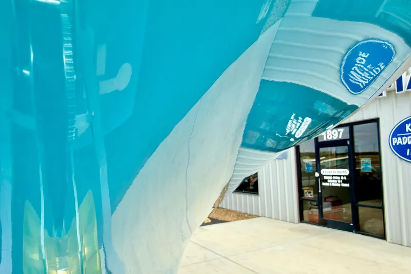 Slide: The Image of Reflection on a 2026 Key West 219 FS boat hull near a storefront entrance. - 10