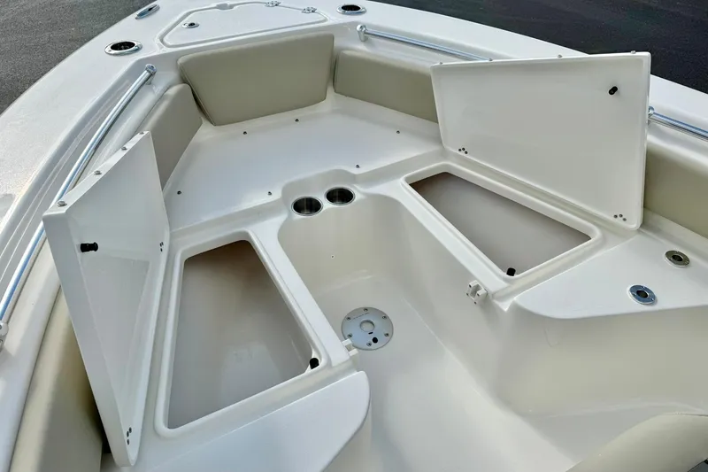 Slide: The Image of 2026 Key West 219 FS boat interior with open storage compartments and cup holders. - 16