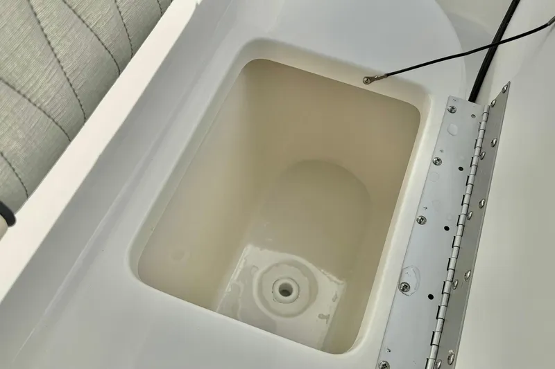 Slide: The Image of Open storage compartment on 2026 Key West 219 FS boat, featuring a sturdy hinge. - 18