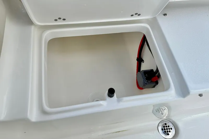 Slide: The Image of Open storage compartment in 2026 Key West 219 FS boat, featuring wiring and drainage. - 33