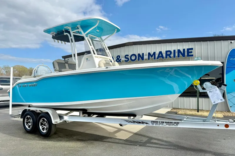 Slide: The Image of 2026 Key West 219 FS boat in vibrant blue on trailer at marine dealership. - 4