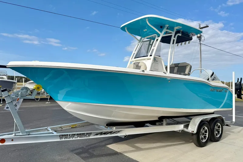 Slide: The Image of 2026 Key West 219 FS boat on trailer, vibrant blue hull, clear sky background. - 5
