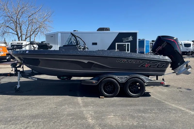 The Image of 2023 Nitro ZV20 fishing boat on trailer, parked outdoors under clear blue sky. - 0
