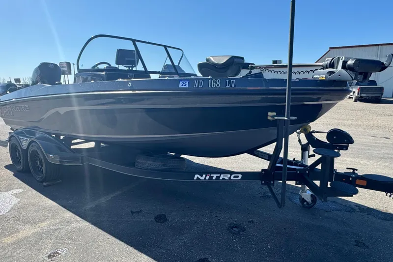 Slide: The Image of 2023 Nitro ZV20 boat on trailer, parked outdoors under clear blue sky. - 2
