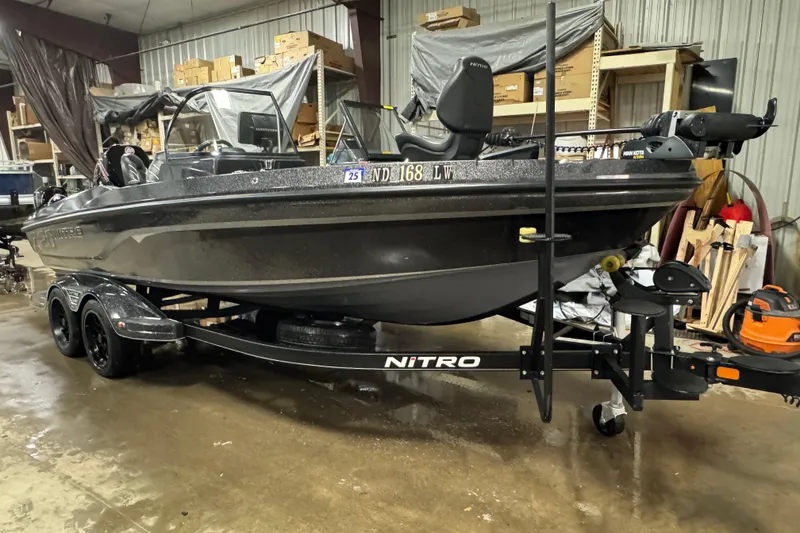 Slide: The Image of 2023 Nitro ZV20 boat in a warehouse, on a trailer, surrounded by equipment. - 26