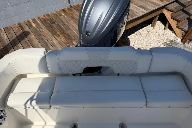 Slide: The Image of 2026 Key West 203 FS boat interior with cushioned seating and outboard motor. - 13
