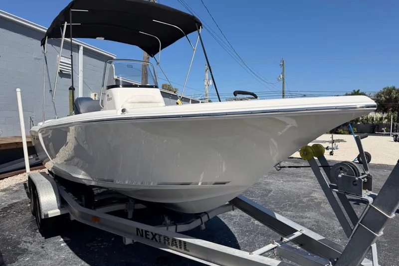 Slide: The Image of 2026 Key West 203 FS boat on trailer with canopy, parked outdoors under clear blue sky. - 5
