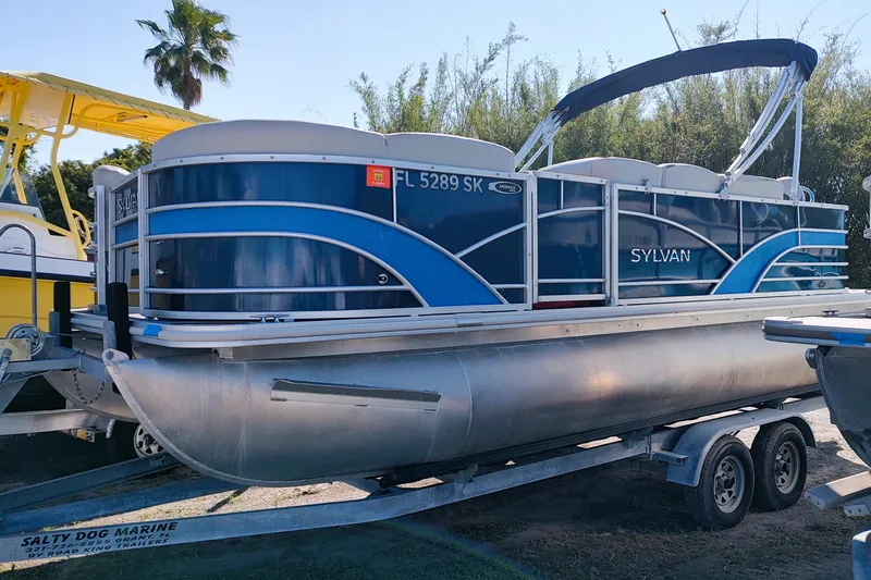 The Image of 2019 Sylvan Mirage Fish 8520 Party Fish pontoon boat on trailer, blue and silver design. - 0