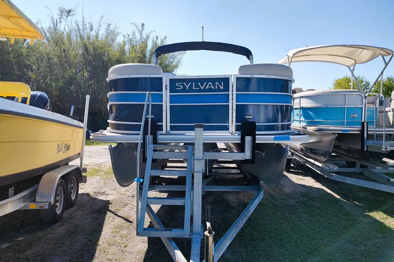 Slide: The Image of 2019 Sylvan Mirage Fish 8520 Party Fish pontoon boat on trailer, parked outdoors. - 11