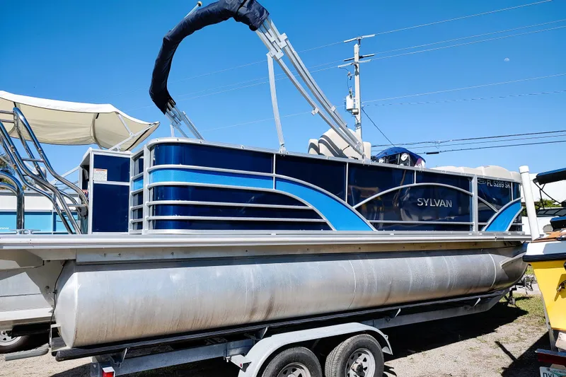 Slide: The Image of 2019 Sylvan Mirage Fish 8520 Party Fish pontoon boat on trailer, blue and silver design. - 7