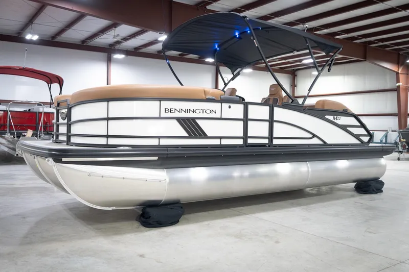 Slide: The Image of 2026 Bennington 22 MSB pontoon boat in a showroom with canopy and seating. - 4