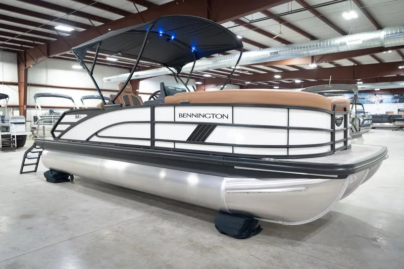 Slide: The Image of 2026 Bennington 22 MSB pontoon boat in showroom with canopy and sleek design. - 6