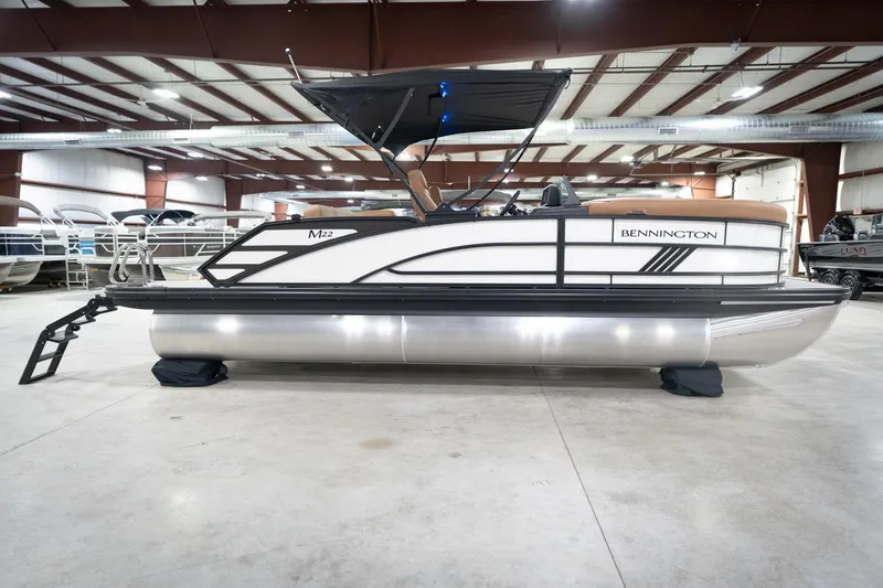 Slide: The Image of 2026 Bennington 22 MSB pontoon boat in a spacious indoor showroom. - 7