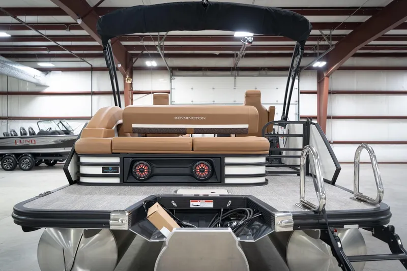 Slide: The Image of 2026 Bennington 22 MSB pontoon boat in a spacious indoor showroom. - 9