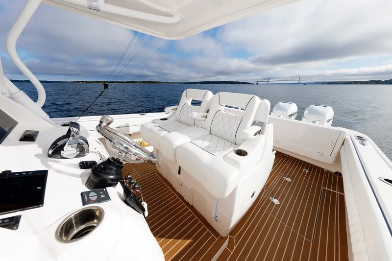 Slide: The Image of 2017 Intrepid 375 Nomad FE boat interior with luxurious seating and modern controls on open water. - 43