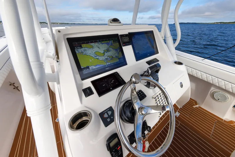 Slide: The Image of 2017 Intrepid 375 Nomad FE boat helm with navigation screens and steering wheel. - 49