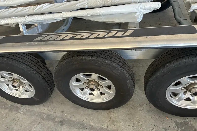 Slide: The Image of Trailer with Intrepid branding, featuring three wheels, for 2017 Intrepid 375 Nomad FE boat. - 67
